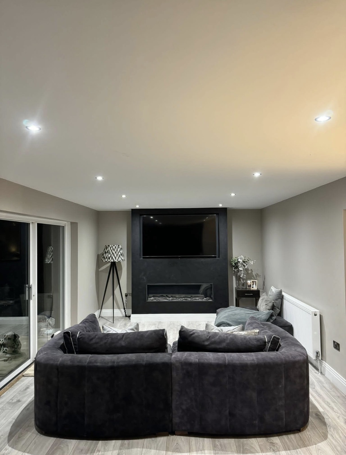 Living area illuminated by a series of recessed ceiling lights